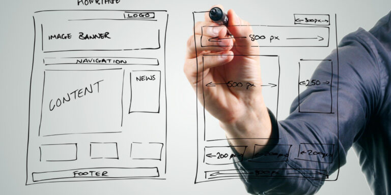 A man is drawing on a screen with a sketch of a website.