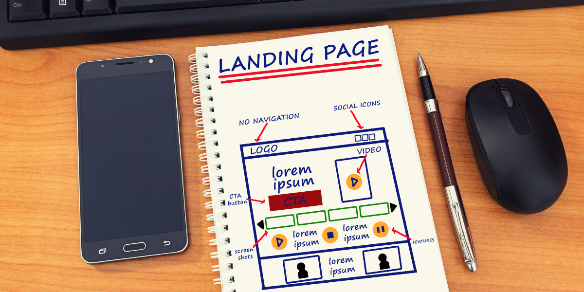 A notebook with the word landing page on it next to a cell phone.