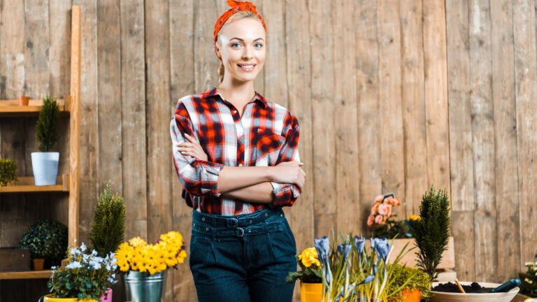 A young woman standing in front of a flower shop.